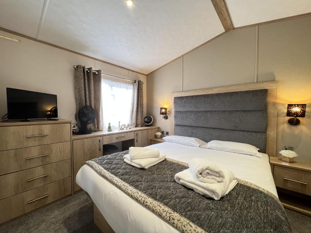 a bedroom with a bed with towels on it at Stewarts Resort Lodge 3 in St Andrews