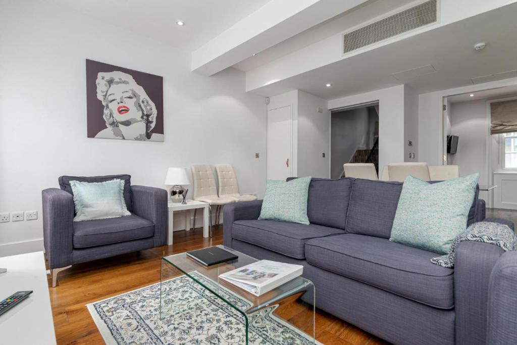 倫敦的住宿－A Stunning Three Bedroom Home in Mayfair，客厅配有紫色沙发和两把椅子