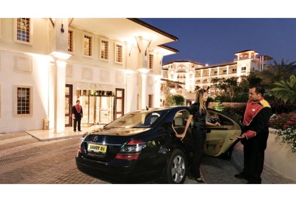 Ein Mann und eine Frau steigen in ein Auto in der Unterkunft Savoy Hotel Spa & Casino in Kyrenia