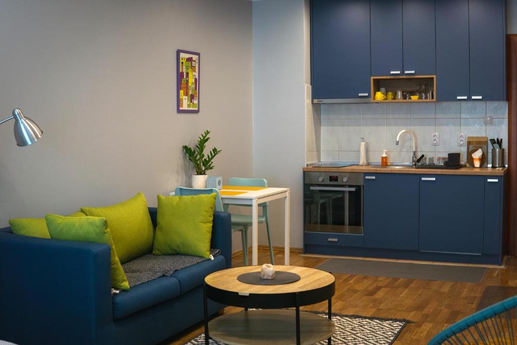 een woonkamer met een bank en een keuken bij Boulevard Studio Apartment in Novi Sad