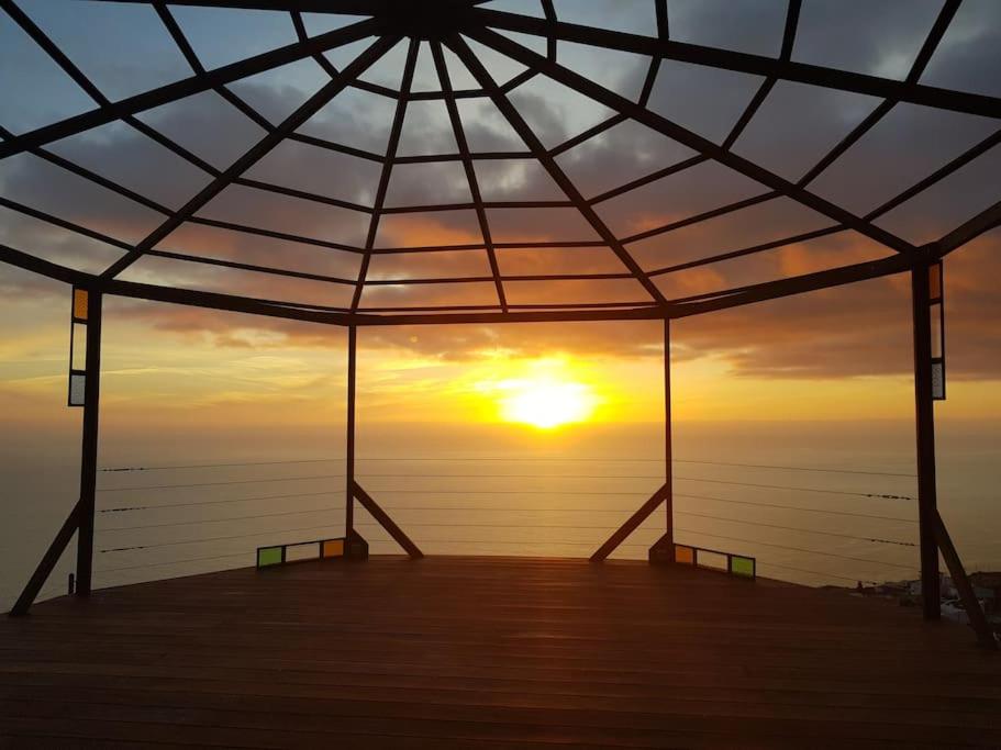einen Blick auf den Sonnenuntergang von einem Pavillon in der Unterkunft El Quinto Pino apartamento con zonas comunes compartidas in Las Indias
