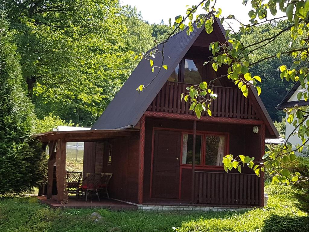 a small red cabin with a gambrel roof at Malastow Mały Domek in Małastów