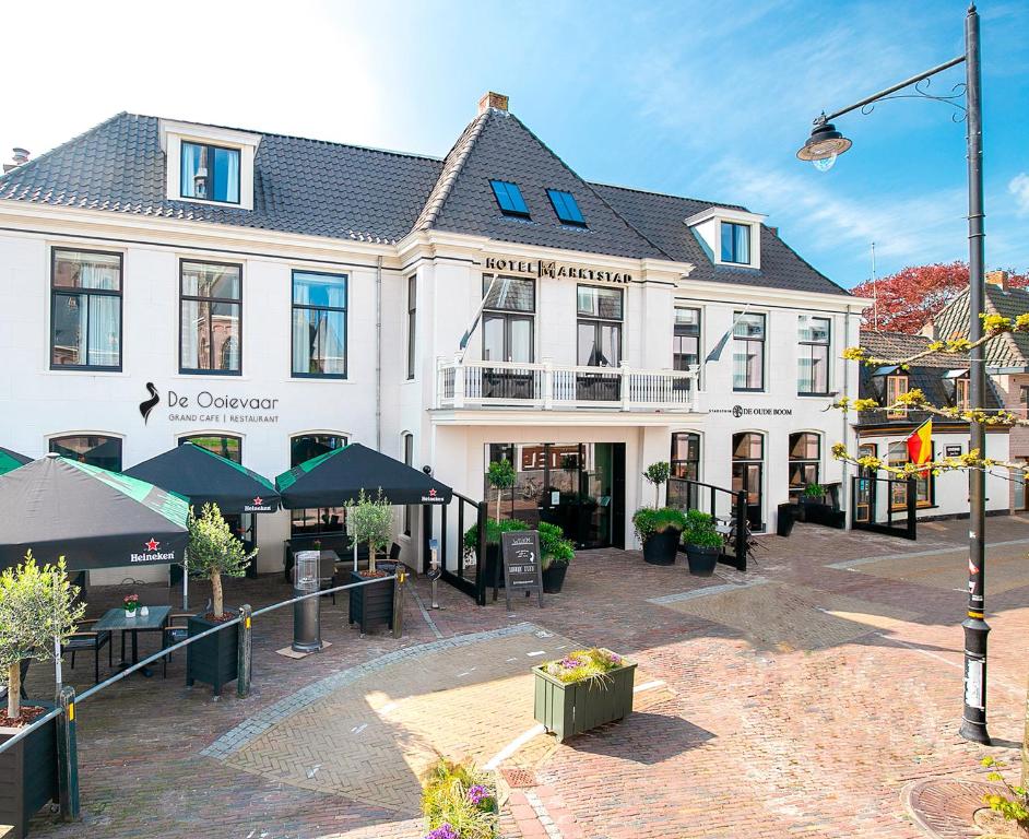 een groot wit gebouw met een binnenplaats ervoor bij Hotel Marktstad in Schagen