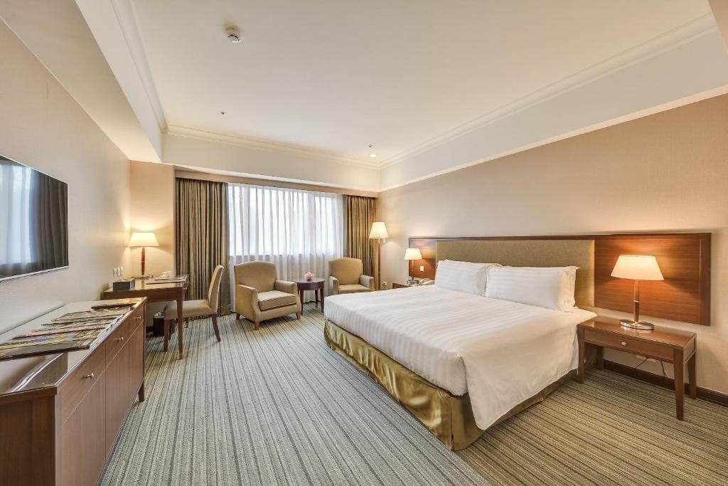 XizhiにあるFuji Grand Hotelのベッドとデスクが備わるホテルルームです。