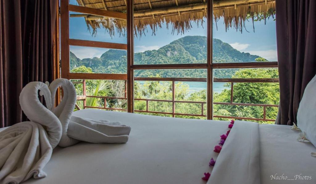 a bed in a room with a large window at Phi Phi Sea Sky Resort in Phi Phi Islands