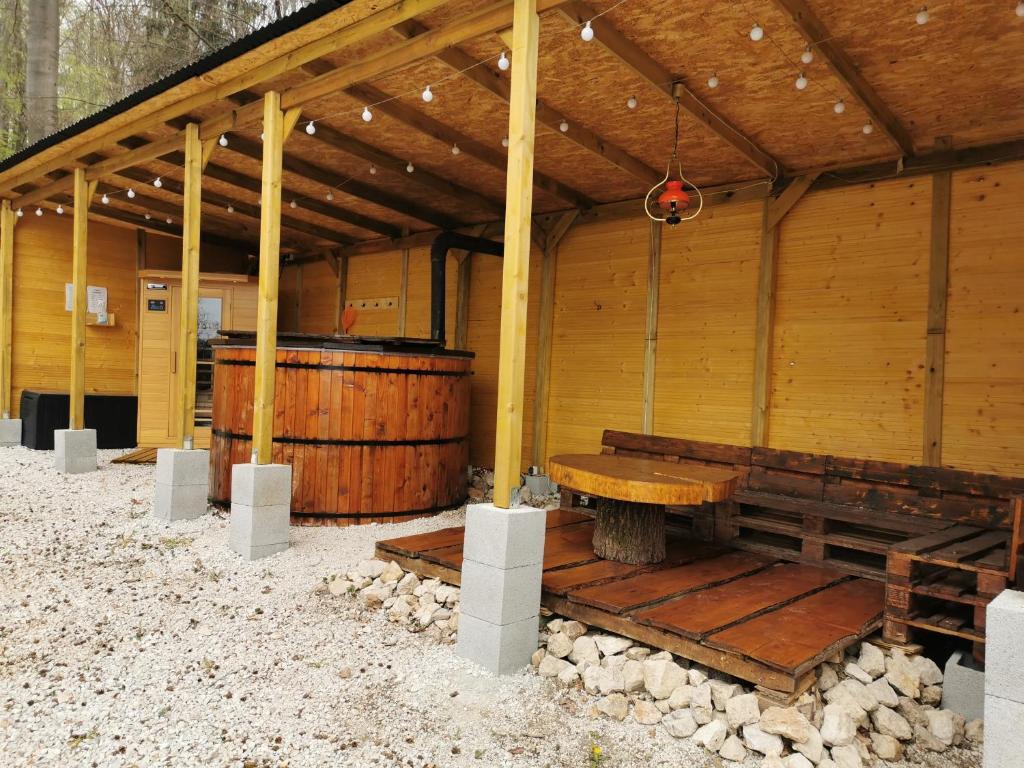 a wooden pavilion with a wooden bench and a table at Déjá Vu Szállás & Rendezvény Zirc in Zirc