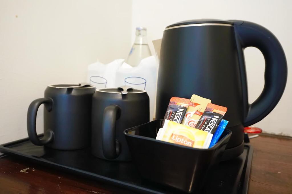 a tray with two black coffee mugs on a table at Montree Phuket Hotel in Phuket Town
