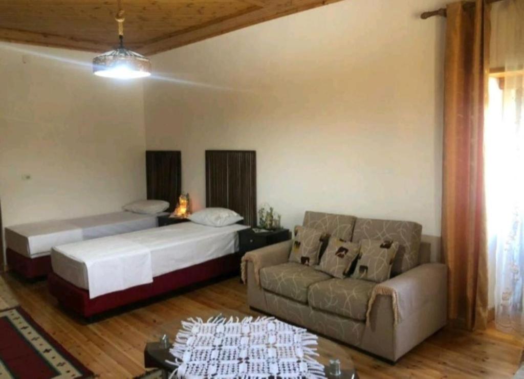 un soggiorno con due letti e un divano di MiziriGuestHouse a Gjirokastër