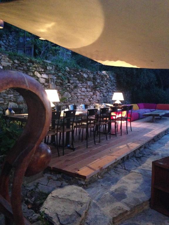 a restaurant with tables and chairs and a stone wall at BBQ Lodge in Camogli
