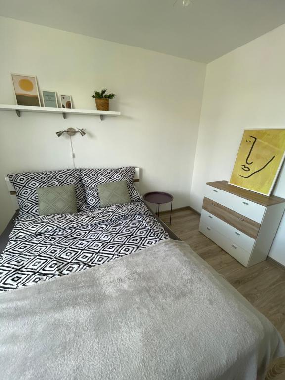 ein Schlafzimmer mit einem Bett und eine Kommode mit einer Lampe in der Unterkunft Apartament Wałbrzych in Wałbrzych