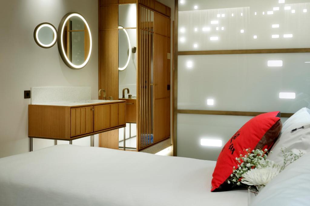 a bedroom with a bed with a red pillow and a bathroom at Hard Rock Hotel Madrid in Madrid