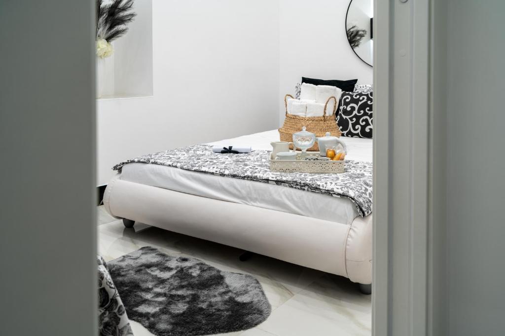 ein weißes Bett in einem Zimmer mit Spiegel in der Unterkunft Ferdinando's Home in Neapel