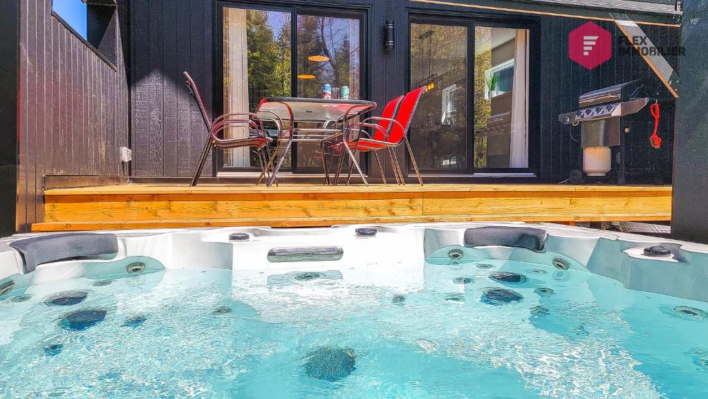 a hot tub with a table and chairs in it at La Villa Éden-SPA de Portneuf / Relaxation and activities aplenty in Pont-Rouge