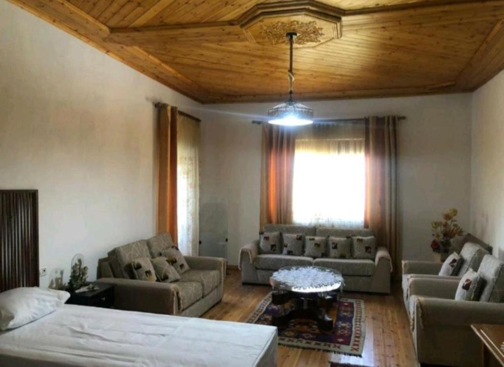 un soggiorno con mobili e soffitto in legno di MiziriGuestHouse a Gjirokastër