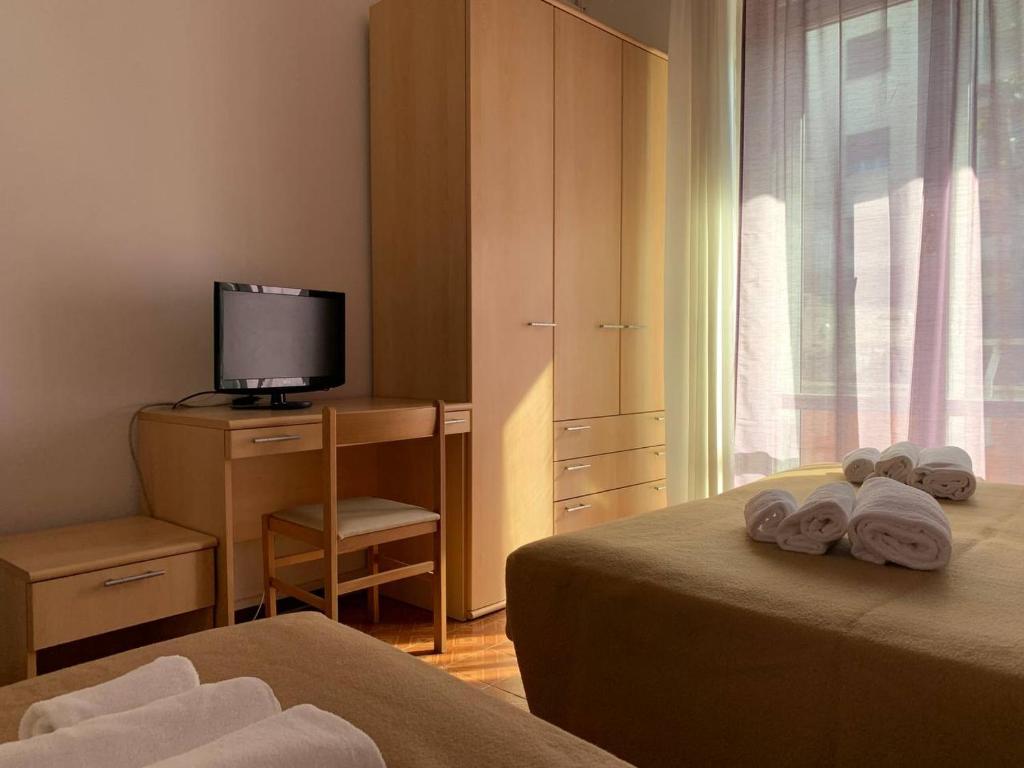 Habitación de hotel con 2 camas y TV en Amica, en Salsomaggiore Terme