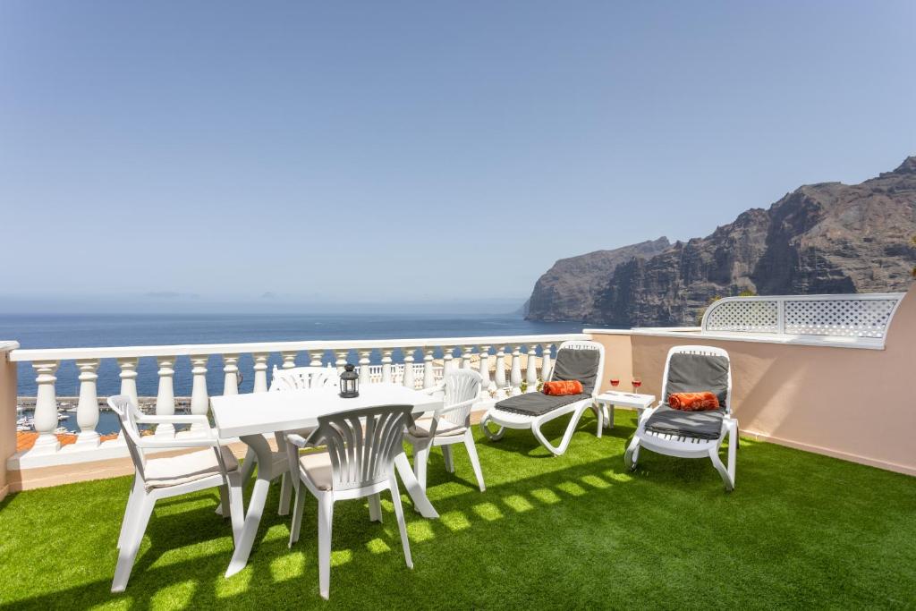 a balcony with a table and chairs and the ocean at Unique Buenavista in Santiago del Teide