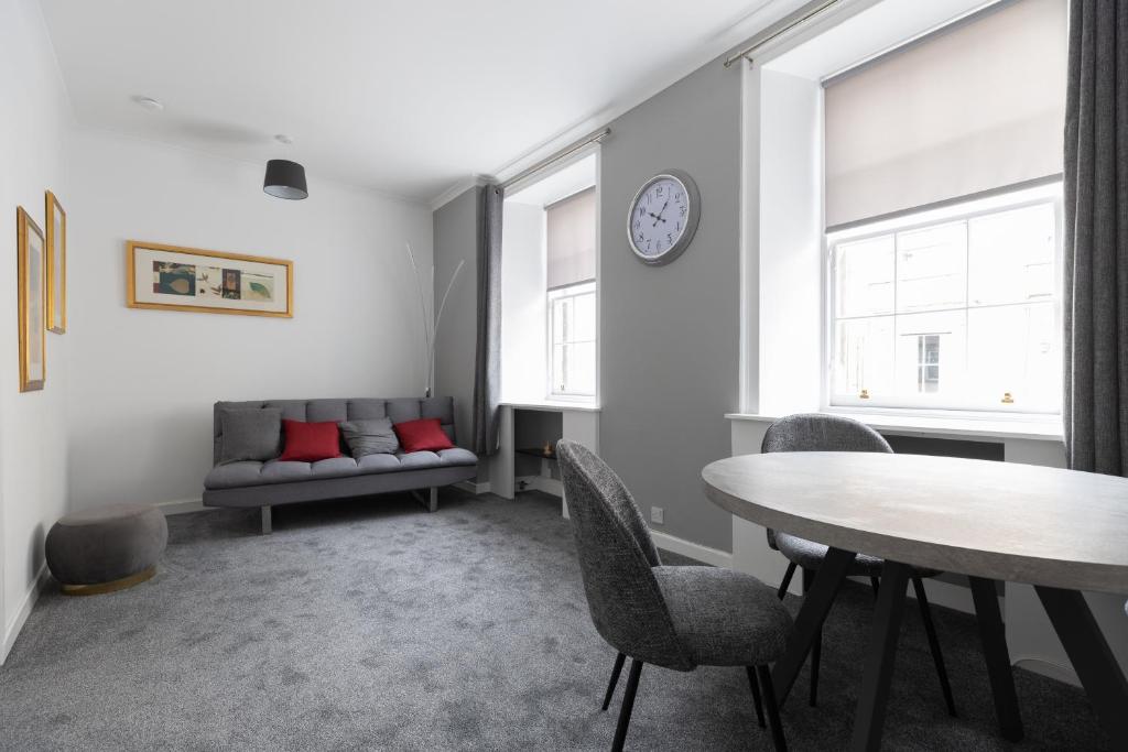 een woonkamer met een tafel en een bank bij Lovely City Centre 1 bedroom flat. in Perth