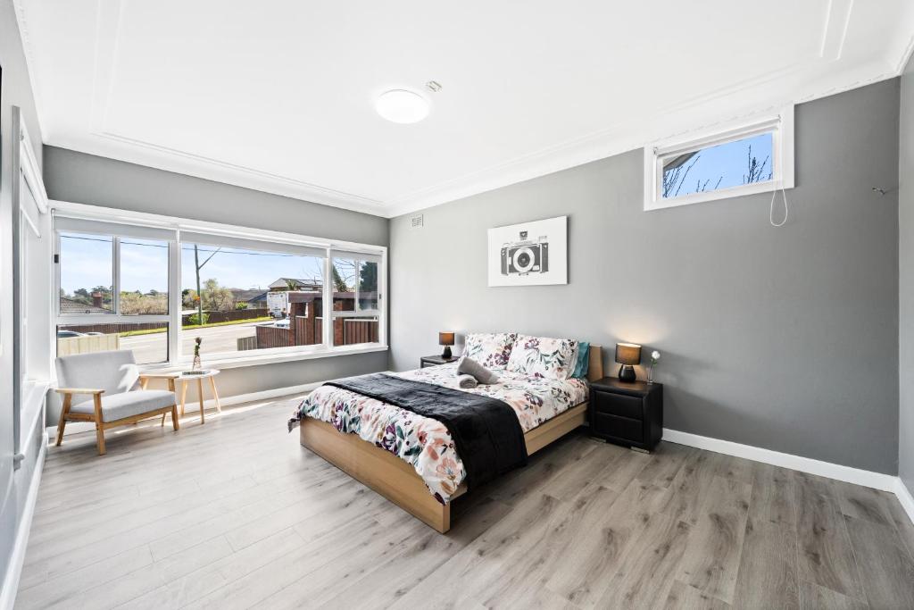 1 dormitorio con cama, escritorio y ventana en New 2 Bedroom House 500m to Mall with Free Parking en Bankstown