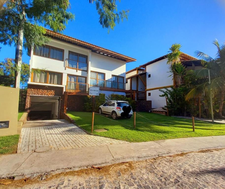 una casa con un coche aparcado delante en Ohana Praia do Forte, en Praia do Forte
