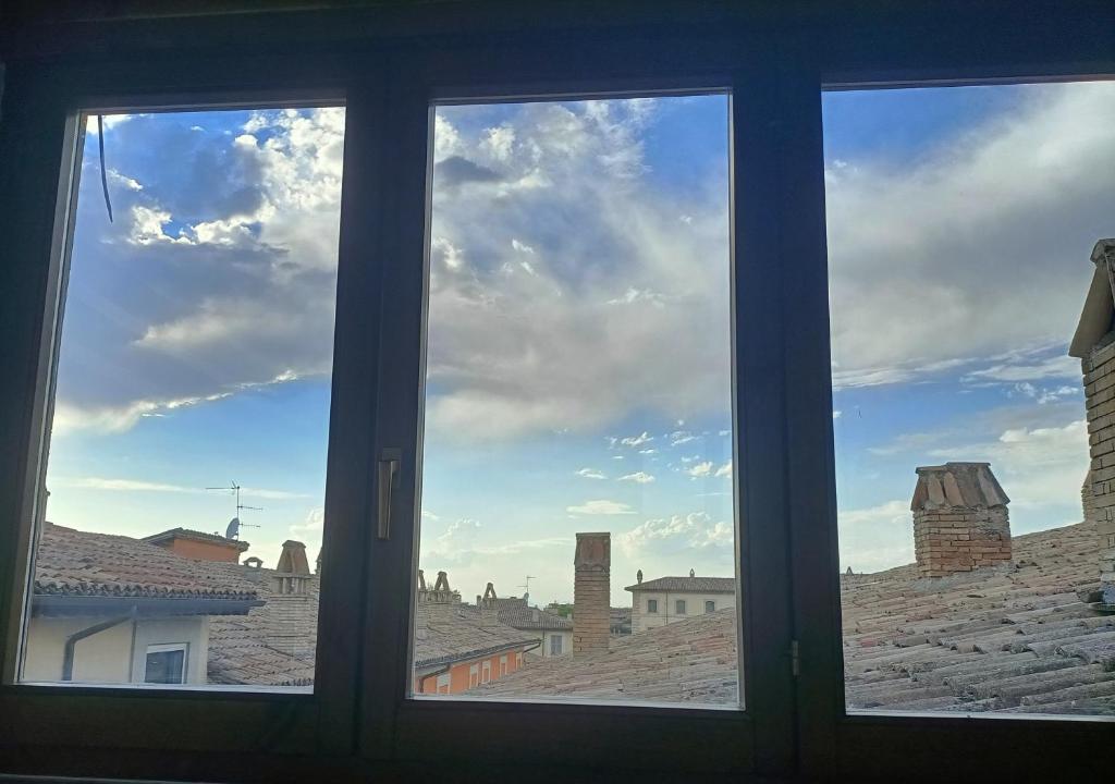 a window looking out at a view of a city at Il cielo in una stanza in Foligno