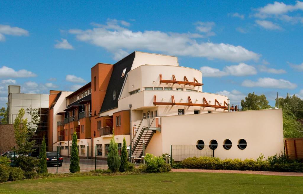 a building with a staircase on the side of it at Holiday Beach Budapest Wellness Hotel with Sauna Park in Budapest