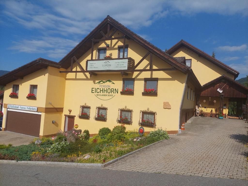 un bâtiment avec un panneau sur son côté dans l'établissement Pension Eichhorn, à Bayerisch Eisenstein