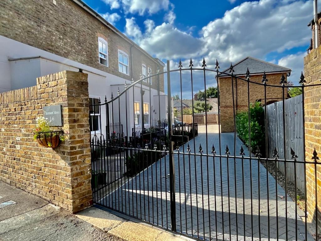 a black wrought iron fence in front of a house at Entire house, Only 25 mins to London, FREE Cancellation 48hrs prior to arrival in West Byfleet