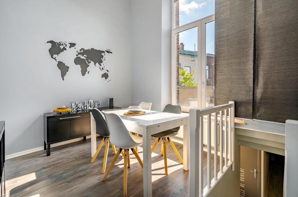 un comedor con una mesa y un mapa mundial en la pared en Appartement 20 min du Circuit Spa-Francorchamps, en Verviers