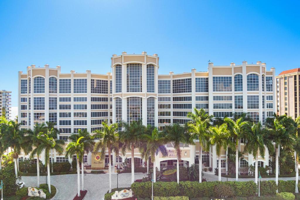 ein großes Gebäude mit Palmen davor in der Unterkunft Marco Beach Ocean Suites in Marco Island