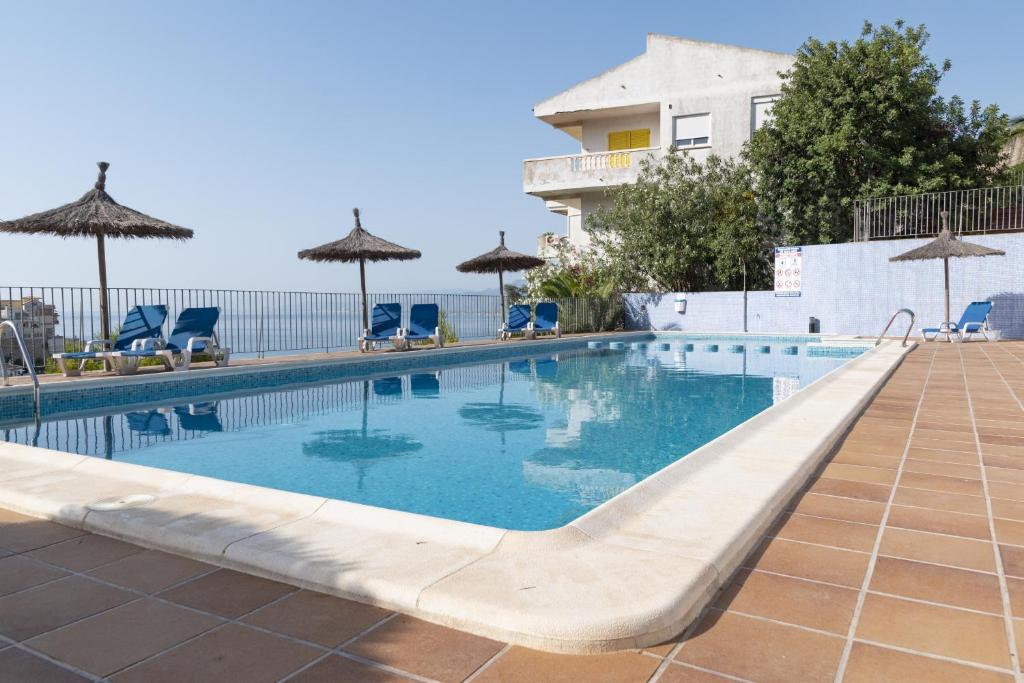 a swimming pool with chairs and umbrellas at Nueva Vista 2º-4 in Cullera