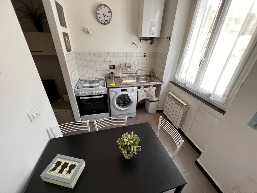 a kitchen with a table and a sink and a stove at Appartamento Low-cost Fillak in Genoa