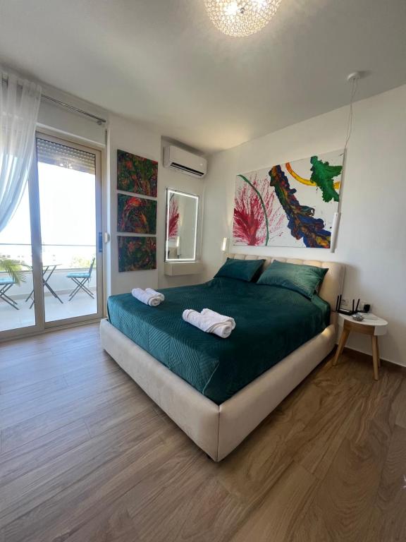 una camera con letto e piumone verde di Sunny breeze apartment a Vlorë