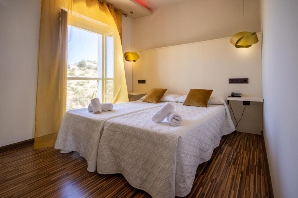 a bedroom with a bed with a large window at Hotel Villa De Setenil in Setenil