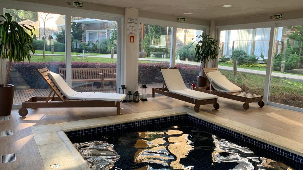 un salon avec un bassin à carpes koï au milieu d'une maison dans l'établissement APTO C/PISCINA AQUECIDA! Vc vai se surpreender!, à Gramado