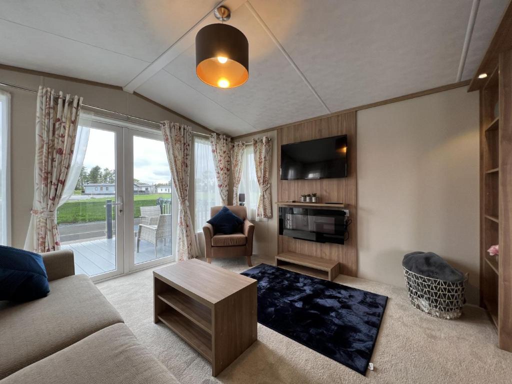 a living room with a couch and a table at Stewarts Resort Lodge 54 in St Andrews