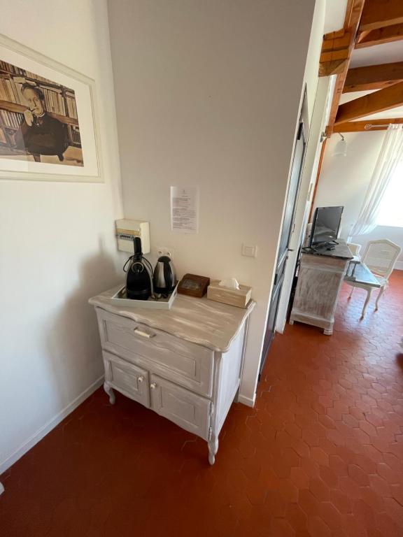 a room with a dresser and a staircase with a desk at Manoir d&#39;Amaury - Chambres d&#39;hôtes in Gréoux-les-Bains