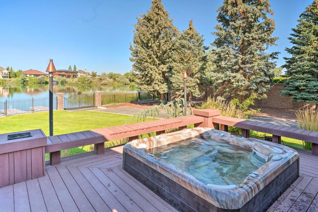 a hot tub on a deck with a bench and a picnic table at Moses Lake Retreat with Salt Water Hot Tub! in Moses Lake
