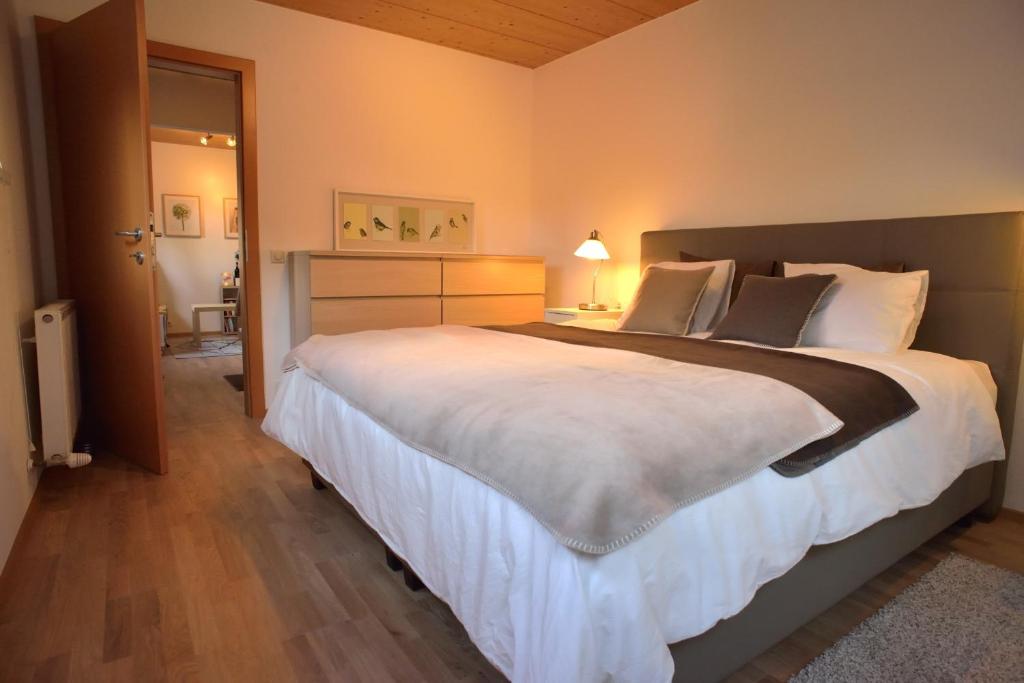 a bedroom with a large bed and a bathroom at Apartment Amberg in Ötztal-Bahnhof