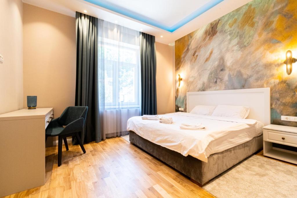 a bedroom with a bed and a desk and a window at Black Gate - Quiet Studio in the Heart of Old Town with Free Private Secured Parking in Braşov