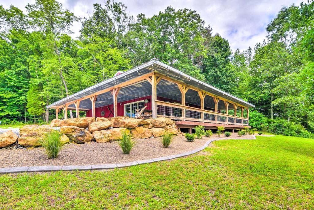 un gran edificio con una pared de piedra en un patio en Secluded Brownsville Cabin with Deck and Fire Pit, en Brownsville