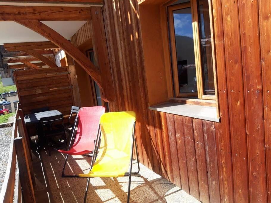 three chairs sitting on the porch of a house at T2 Les orres 1800 : pied des pistes avec piscine in Les Orres