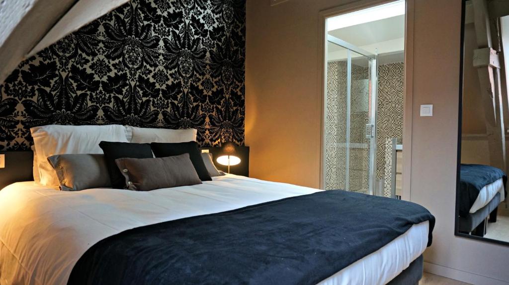 a bedroom with a large bed with a black headboard at Little Suite - Simone in Lille