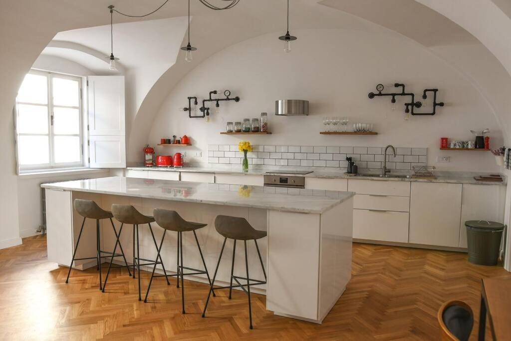 a kitchen with a large white island with bar stools at Beautiful 2bed apartment in the centre of Varazdin in Varaždin