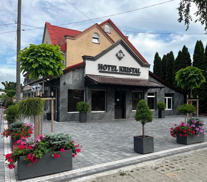 ein Hotel mit Blumen vor einem Gebäude in der Unterkunft Hotel i Restauracja „KRISTAL” in Braniewo