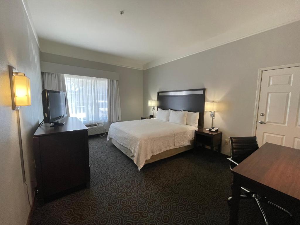 a hotel room with a bed and a flat screen tv at La Quinta by Wyndham Houston West at Clay Road in Houston