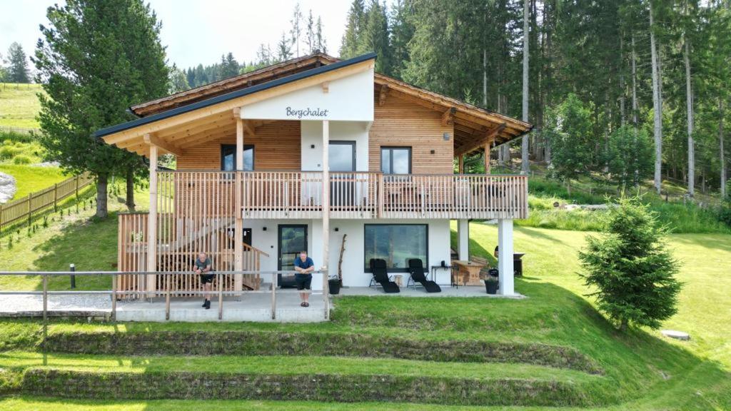 a log cabin with a large deck on a lawn at Bergchalet Dein Paradies in Pruggern