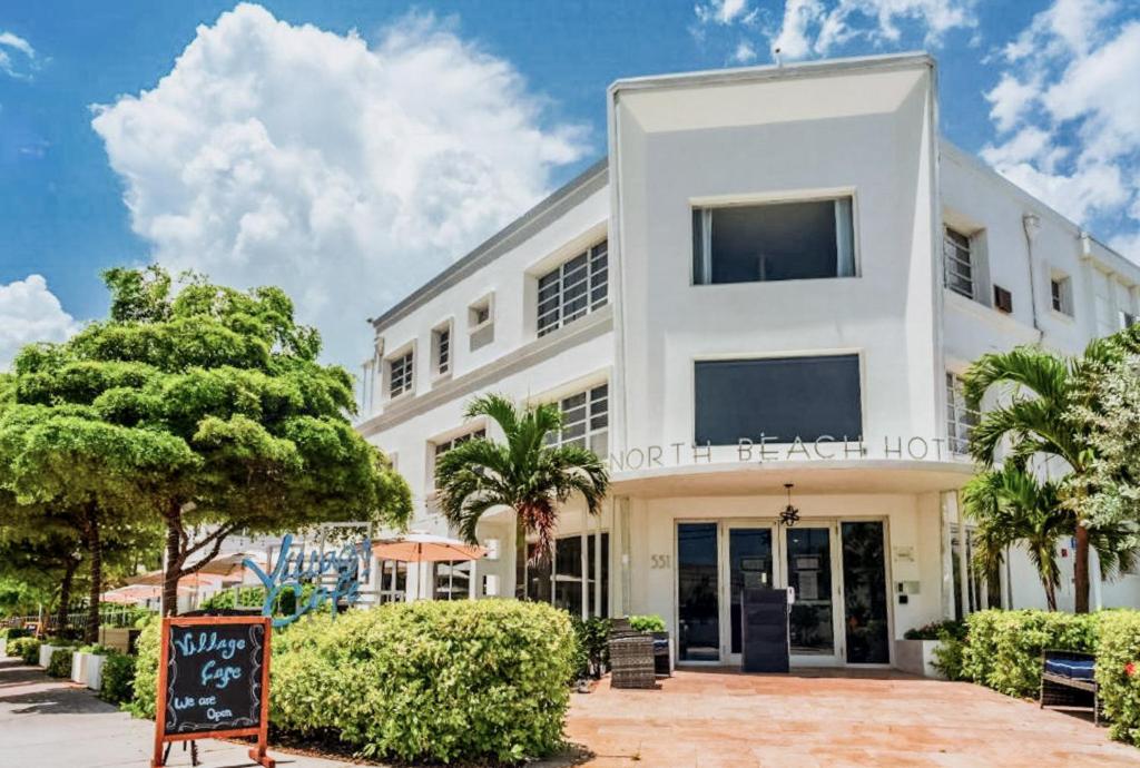 ein weißes Gebäude mit einem Schild davor in der Unterkunft North Beach Hotel in Fort Lauderdale