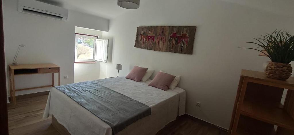 1 dormitorio con 1 cama con 2 almohadas rosas en Casa da Portagem by Portus Alacer en Marvão