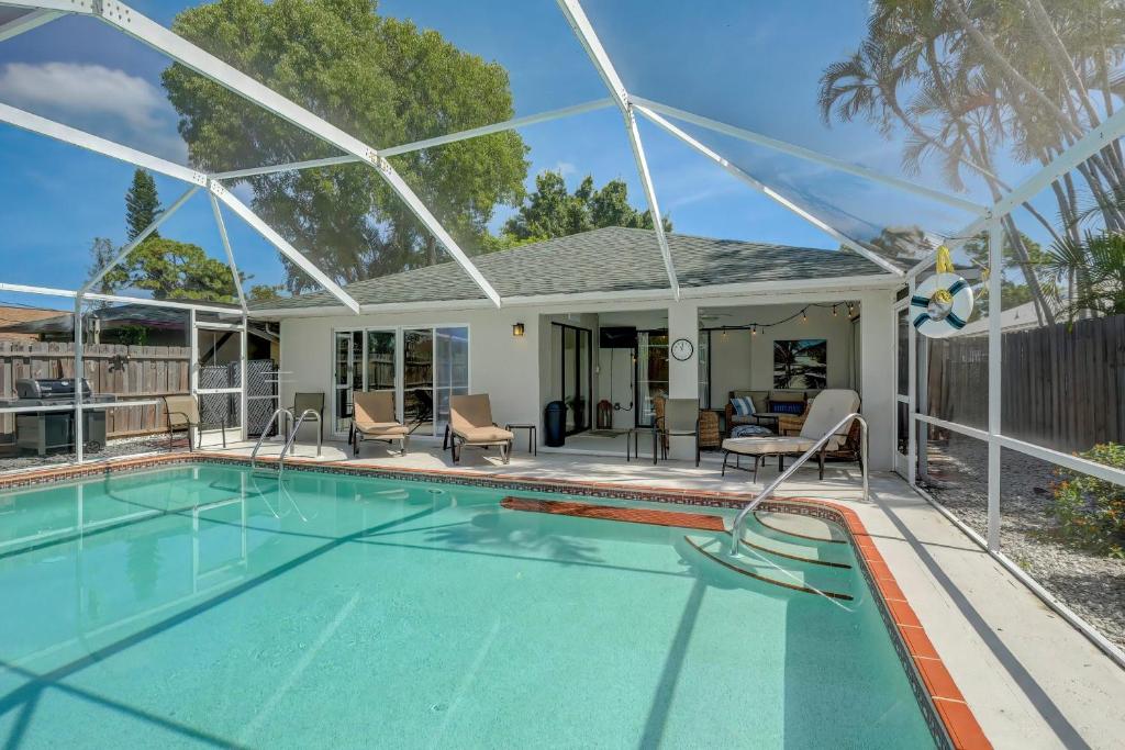 a swimming pool in front of a house at Walk to Vanderbilt Beach From Our Naples Park Home in Naples