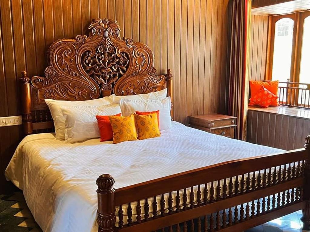 a bedroom with a large bed with a wooden headboard at Fort Bridge View in Cochin